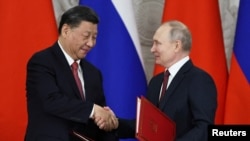 资料照 - 习近平访问俄罗斯期间同俄罗斯总统于2023年3月21日在莫斯科克里姆林宫举行了会谈,两人在签署公报后握手祝贺。