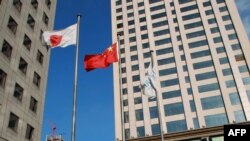 资料照:大连市商业区楼群中飘扬的中日国旗。(2012年12月31日)