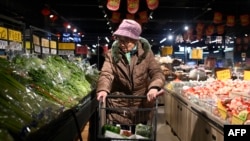北京一名妇人在超级市场采买食品。为避免陷入通货紧缩,中国官员们正在努力刺激这个世界第二大经济体的消费活动。(法新社:2025年1月9日)
