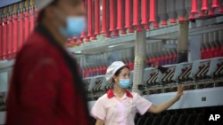 中国政府2021年4月组织外媒参观新疆一个棉纺厂,试图反击国际社会有关新疆强迫劳动的指责。(美联社)