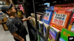 资料照:一名男子在北京一家书店的新版地图展架前。(2023年9月1日)