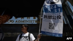 一名志愿者在街头举旗让公众意识到澳门非正式公投。(2014年8月24日)