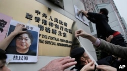 香港抗议者在北京驻香港机构中联办前贴上铜锣湾书店失踪老板 桂民海 的照片。 (2016年1月3日)