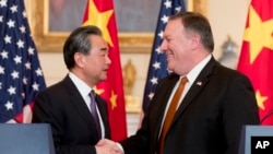 美国国务卿蓬佩奥和中国国务委员兼外长王毅在美国国务院联合举行记者之后握手。(2018年5月23日)