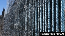 Border wall reinforced with barbed wire to prevent migrants from illegally entering into the United States.