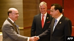 美国商务部长罗斯(左)在泰国首都曼谷出席东盟会议期间与中国总理李克强(右)握手(2019年11月4日)。