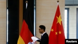 在北京举行中德经贸部长会议期间一名男子走过中国和德国国旗。(2016年11月1日)