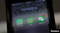 Whatsapp、阿里巴巴的来往和微信的图标并列在北京拍摄的一只手机上。(2014年2月24日)