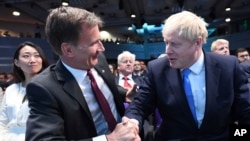 英国外相亨特祝贺约翰逊(右)当选英国首相。