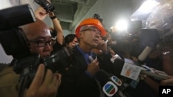 苹果日报记者韩耀庭因向胡锦涛提六四问题而被警方带走后,记者和摄影师现场围住一名香港警察(6月30日)