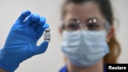 英国伦敦的盖伊医院,一名医务人员拿着一剂辉瑞/BioNTech生产的新冠疫苗(2020年12月8日)。