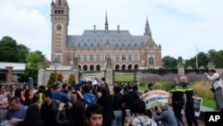 资料照片:海牙国际仲裁庭宣布裁决结果之前,海牙和平宫外面聚集着示威者、警察和记者。(2016年7月12日)