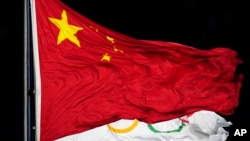 2022年2月4日,在北京举行的2022年冬奥会开幕式上飘扬的中国国旗和奥林匹克旗帜