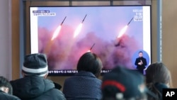 韩国首尔火车站的民众在观看朝鲜再次发射火箭的电视新闻。(2020年3月9日)