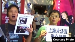 上海访民星期一在高院外举牌抗议法官集体嫖娼和司法腐败 (图片来源:民生观察网)