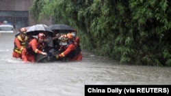 中国安徽救援人员在大雨中疏散合肥居民。(2021年7月8日)