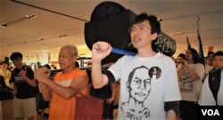 现年75岁的香港社运人士 古思尧 (左)2013年5月26日参与前学民思潮平反六四游行,与社民连前主席吴文远,抬着道具棺材游行经过一间百货公司 (美国之音汤惠芸)