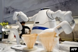 资料照片:在北京冬奥会开幕前,在张家口太子城站的一处“闭环管理”区域,机器人在等候区烧热水。(2021年1月29日)