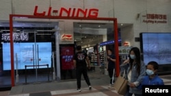 人们走过北京街头的一家中国运动服装品牌李宁公司的专卖店。(2021年4月15日)
