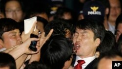 2013年9月5日,韩国左派国会议员李石基(右)在首尔被逮捕后在警察和记者簇拥下高声喊叫。
