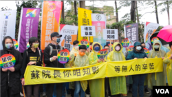 台湾跨国同性伴侣和同性恋权益团体2月14日西洋情人节冒雨于台北行政院外集会陈情,他们呼吁台湾政府尽速完成相关法律的修正,以让部分卡关的跨国同婚能早日完成登记。(美国之音记者谭嘉琪拍摄)