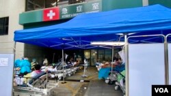 香港第5波新冠病毒疫情引致公营医疗系统超负荷,多间公立医院急症室逼爆,大批病人被安置在户外的病床上,有怀疑确诊者及家人,到私立医院急症室求诊 (美国之音/汤惠芸)