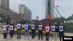 中国民众走上湖南岳阳街头举牌呼吁彻查锁链女奴案。(取自推特照片)
