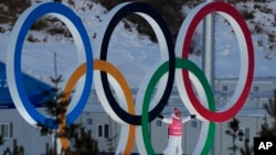 一名运动员站在北京冬奥赛场的奥运会五环里。(2022年2月3日)