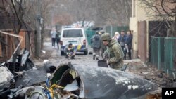 Kyiv မြို့ထဲပျက်ကျခဲ့တဲ့ လေယာဉ်ငယ်တစင်းကို ယူကရိန်းစစ်သားတဦးက စစ်ဆေးနေစဉ်။ (ဖေဖေါ်ဝါရီ ၂၅၊ ၂၀၂၂)