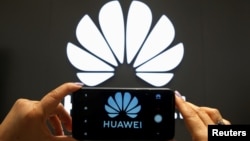资料照:一支手机屏幕上显示的华为标识。
