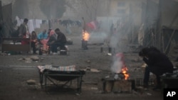 叙利亚难民在保加利亚一处难民营内的露天空地烤火取暖,他们的栖身帐篷没有供暖设施。(2013年11月23日资料照)