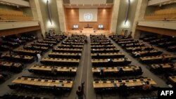 戴着防护口罩、保持社交距离的各国代表出席在日内瓦联合国欧洲总部举行的第44届人权理事会会议。(2020年6月30日)