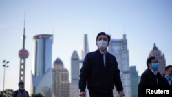 戴着口罩的行人行走在上海陆家嘴金融区的街道上。(2020年3月19日)