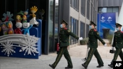 中国武警士兵在北京冬奥会吉祥物前走过。(2022年1月21日)