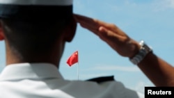 一名驻香港海军基地的中国海军士兵向中国国旗敬礼。(2019年6月30日)