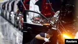 开设在北京的奔驰汽车工厂工人正在生产线上组装汽车。 (2015年8月31日)