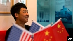 一位16岁的中国学生在北京一家教育机构里的美中两国国旗旁(2014年6月26日)
