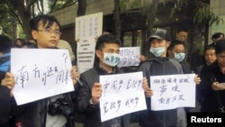 1月8日,示威者手持标语牌站在广州南方周末报社的总部的外面