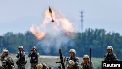 资料照片:2021年5月22日,中国人民解放军士兵在中国安徽省的演习中发射迫击炮弹。