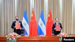 中国外交部副部长马朝旭(右)和尼加拉瓜代表在天津签署联合公报。(2021年12月10日)