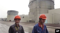 资料照:两名工人走过上海西南方125公里处的秦山核电站。(2005年6月10日)