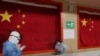 身穿防护服的医护人员在武汉的一所方舱医院里安慰一名病患。(2020年2月27日)