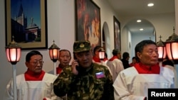 中国天主教徒2018年12月24日在上海的圣诞节前夕参加教堂弥撒,穿迷彩服者为保安人员。