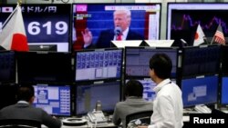 日本东京一个外汇交易公司办公室。电视画面显示美国总统川普和日元兑换率(2017年1月23日)