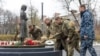 Українські військовослужбовці кладуть колоски до пам’ятника жертвам Голодомору 1932-33 років. Ukrainian Presidential Press Service/Handout via REUTERS