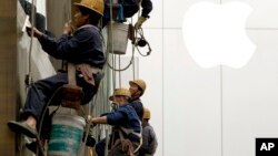 4月10日在北京,工人们在清洗一座建筑物的窗子
