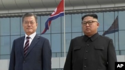 韩国总统文在寅(左)抵达平壤与朝鲜领导人金正恩合影。(2018年9月18日)