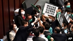 香港立法会泛民主派议员在内务委员会的一个会议期间举牌抗议中国人大制定香港国安法,他们被保安阻拦。(2020年5月22日)