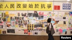 一名女子在香港地铁东涌站的连侬墙前拍照。(2019年8月24日)