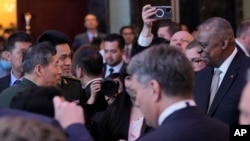资料照:在新加坡的香格里拉安全对话会上,美国国防部长奥斯汀与中国防长李尚福握手并短暂交流。(2023年6月2日)